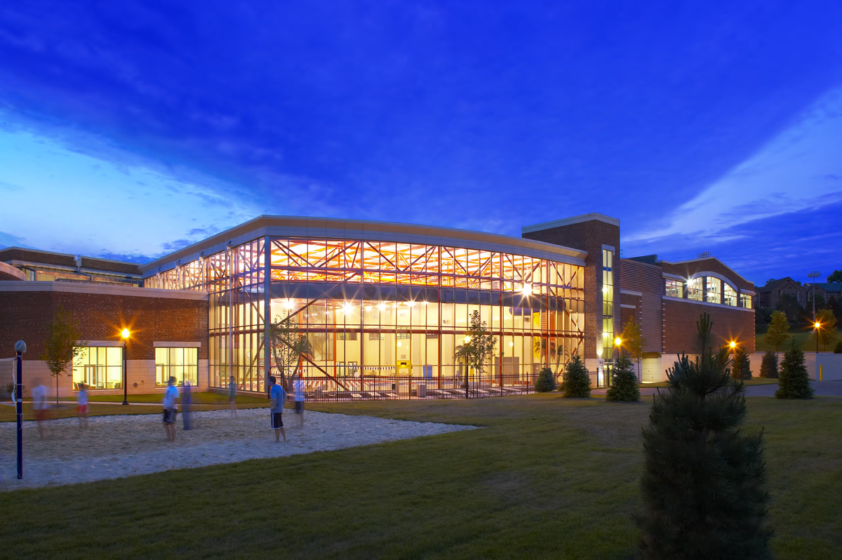 ${ The exterior of the south side of the RecPlex - including the aquatic center and the sand volleyball court - at night }