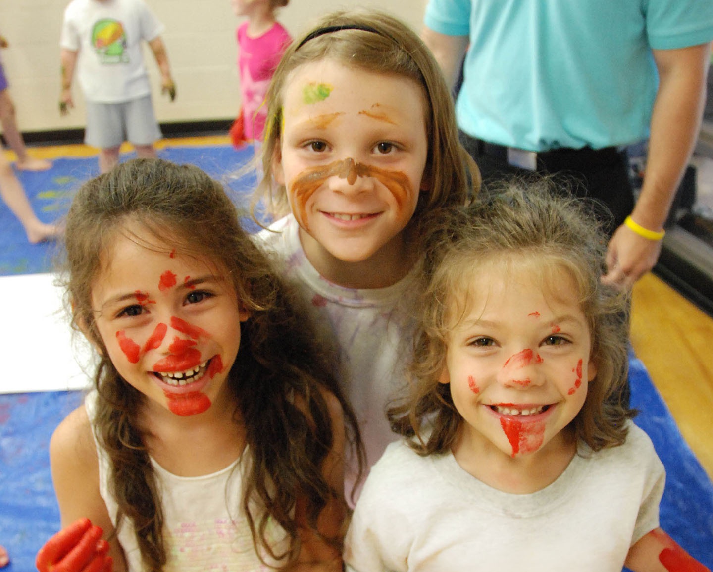 Three RECkids campers smiling showing off their face paints.